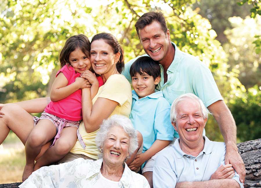 three generations of a family posing for a photo outside