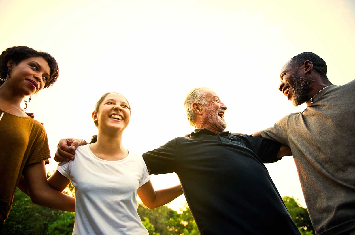 Multi-generational family outside, hugging